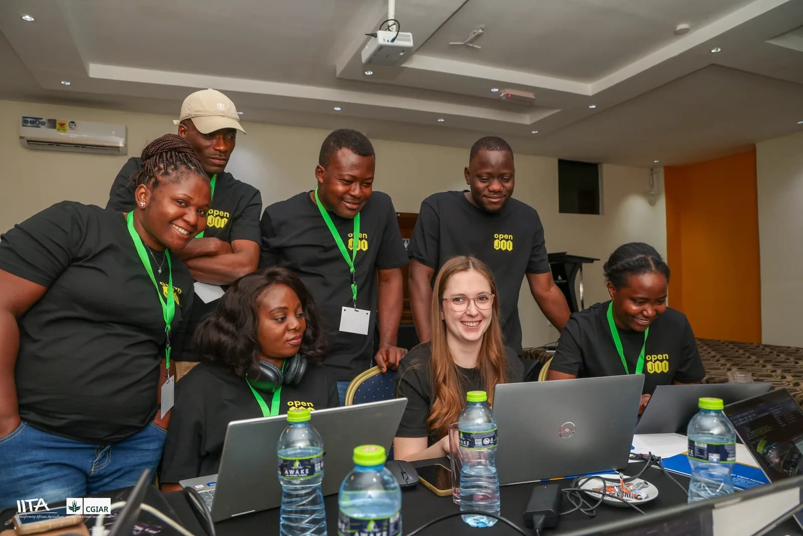A team of hackathon participants gathered around laptops, comparing analyses of a shared field dataset